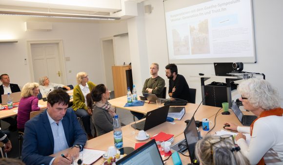 Viele Menschen sitzen in einem Beratungsraum